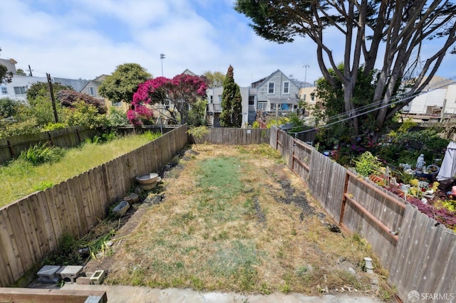 view of yard featuring a fenced backyard and a residential view