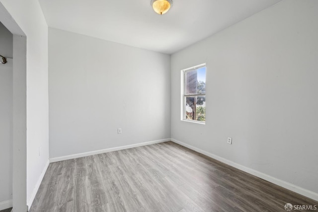unfurnished room with baseboards and wood finished floors