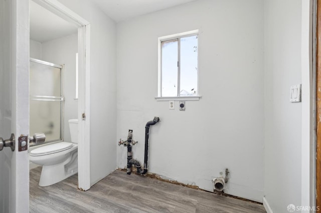 clothes washing area featuring laundry area, electric dryer hookup, and wood finished floors