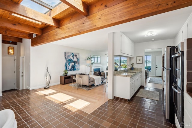 308 E Strawberry Dr, Mill Valley, CA 94941 - kitchen with a sink, open floor plan, light countertops, beam ceiling, and white cabinetry