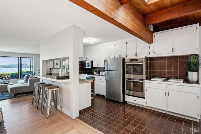 308 E Strawberry Dr, Mill Valley, CA 94941 - kitchen with stainless steel appliances, backsplash, a peninsula, open floor plan, and a breakfast bar area
