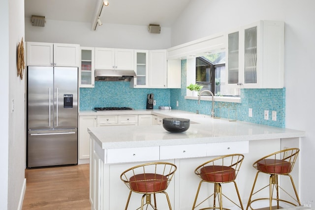 kitchen featuring white cabinets, a breakfast bar area, appliances with stainless steel finishes, and kitchen peninsula