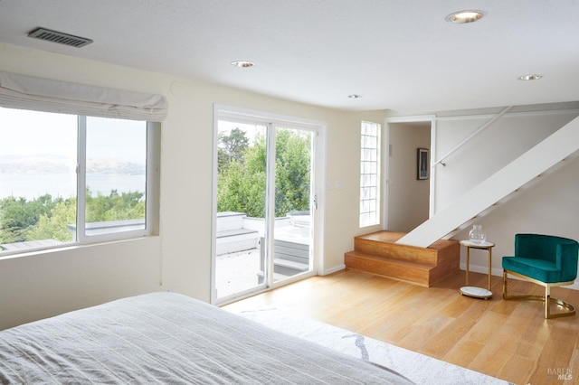 bedroom featuring access to exterior and wood-type flooring