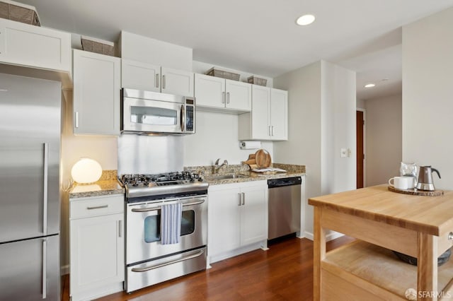 81 Frank Norris St Unit 701, San Francisco, CA 94109 - kitchen featuring stainless steel appliances, dark wood-type flooring, white cabinets, light stone countertops, and recessed lighting