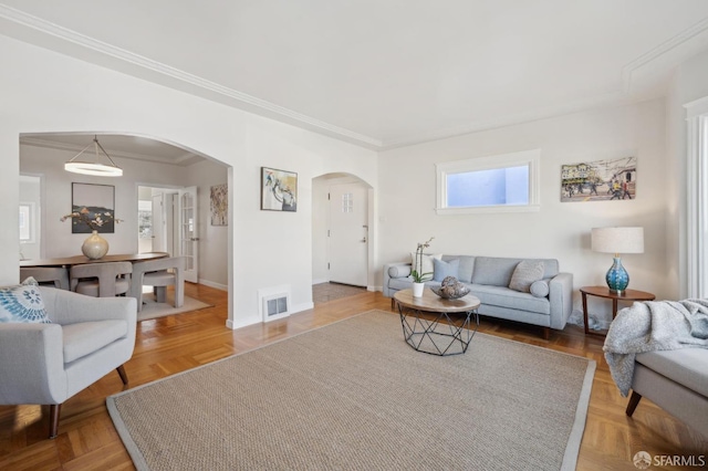 living room featuring baseboards, visible vents, arched walkways, and ornamental molding