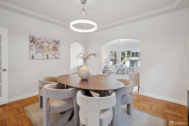 dining room featuring baseboards, arched walkways, and ornamental molding