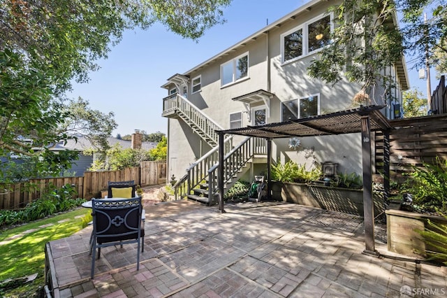 view of patio / terrace featuring stairs and fence