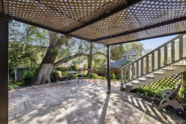 wooden terrace featuring a pergola, fence, an outdoor structure, stairs, and a patio area