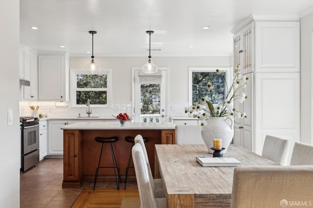 tiled dining space featuring a sink and recessed lighting