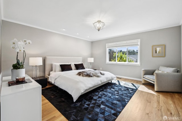 bedroom with crown molding, light wood-style floors, and baseboards