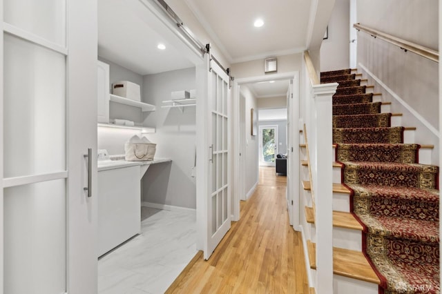 interior space with baseboards, stairway, a barn door, ornamental molding, and washer / dryer