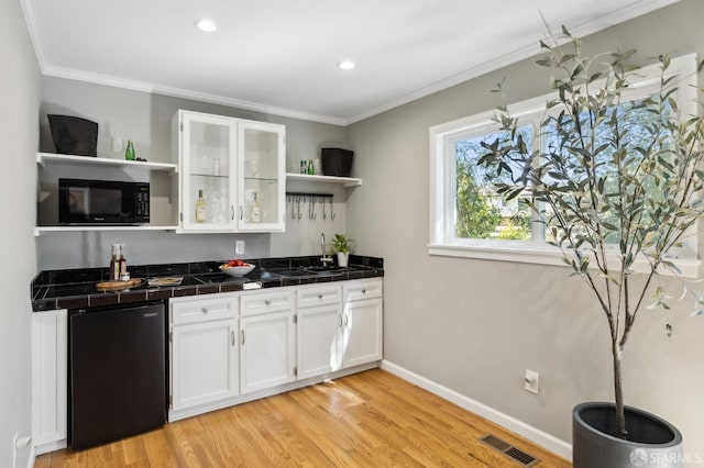 kitchen with visible vents, open shelves, black microwave, fridge, and a sink