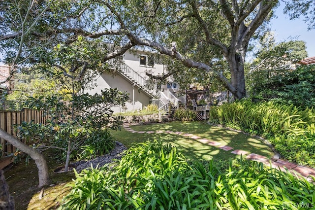 view of yard featuring stairs and fence