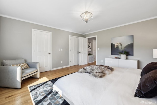 bedroom featuring crown molding, a notable chandelier, wood finished floors, and baseboards