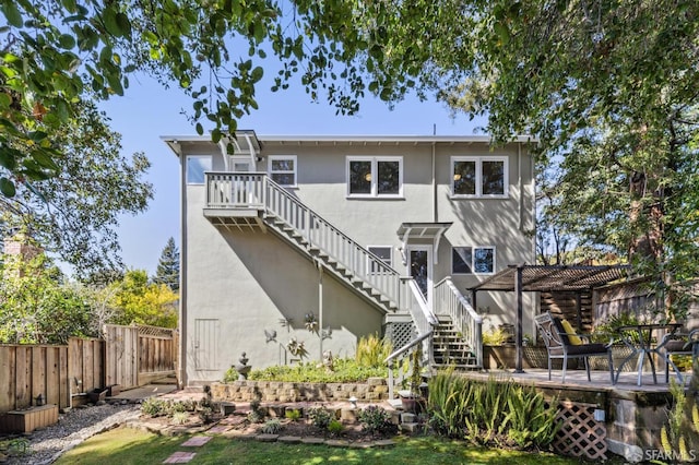 back of property featuring a deck, stairway, a fenced backyard, and stucco siding