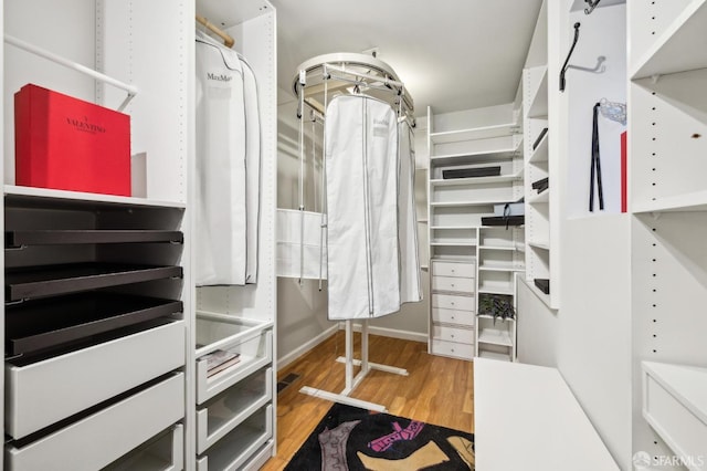 walk in closet with wood finished floors