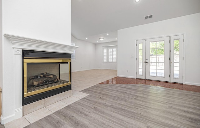 unfurnished living room with a multi sided fireplace, recessed lighting, tile patterned floors, and visible vents