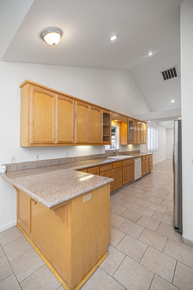 kitchen featuring a sink, dishwasher, freestanding refrigerator, a peninsula, and visible vents