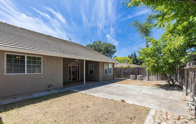 rear view of house with a fenced backyard, ceiling fan, a patio area, and stucco siding