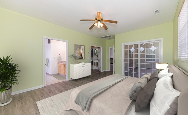 bedroom with visible vents, a spacious closet, wood finished floors, and ensuite bathroom
