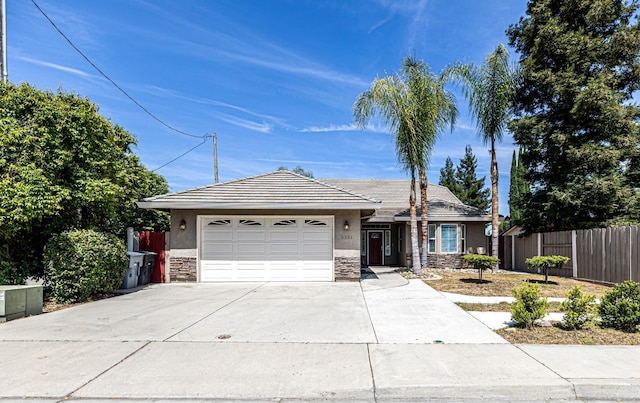 single story home featuring fence, stone siding, stucco siding, an attached garage, and driveway