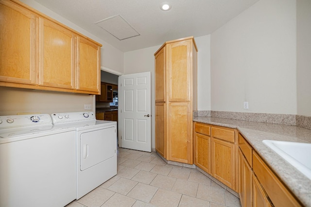 washroom featuring cabinet space, a sink, washing machine and dryer, and light tile patterned floors