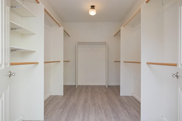 walk in closet with wood finished floors
