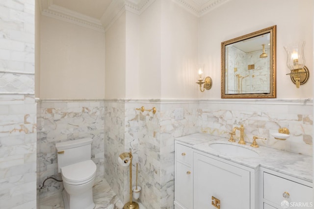 bathroom featuring vanity, toilet, wainscoting, and ornamental molding