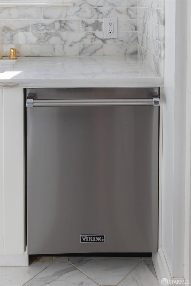 interior details with white cabinets, dishwasher, and light stone countertops