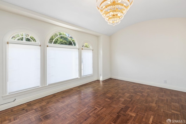 spare room with a chandelier, a healthy amount of sunlight, lofted ceiling, and baseboards