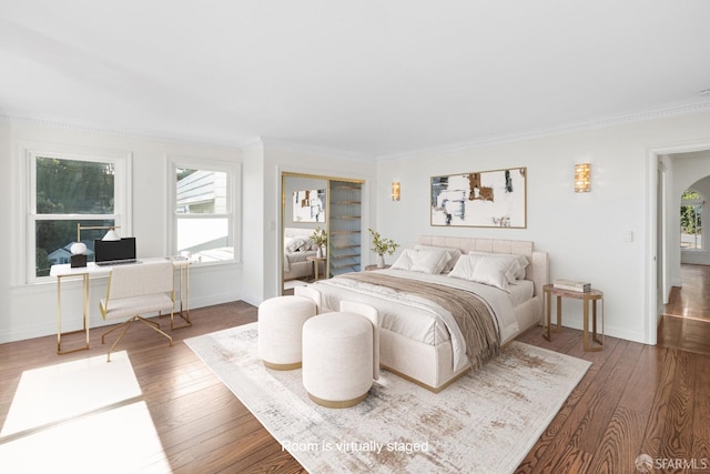 bedroom featuring baseboards, wood-type flooring, and ornamental molding