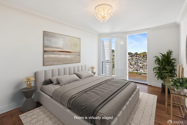 bedroom featuring baseboards, wood finished floors, access to exterior, and ornamental molding