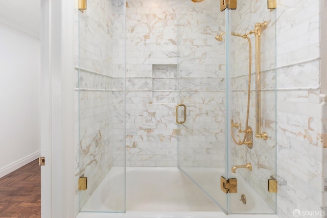 bathroom with baseboards and shower / bath combination with glass door