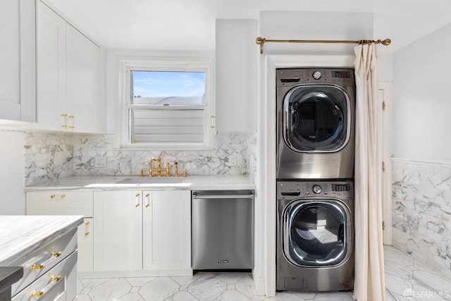 laundry area with a sink, stacked washer and clothes dryer, and laundry area