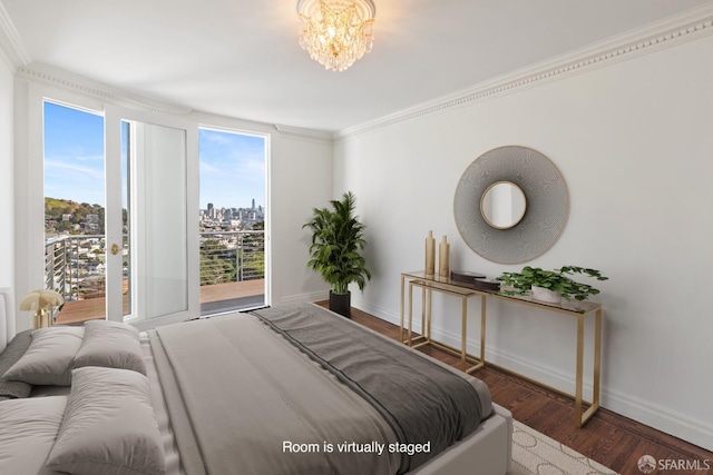 bedroom featuring baseboards, a view of city, wood finished floors, and crown molding