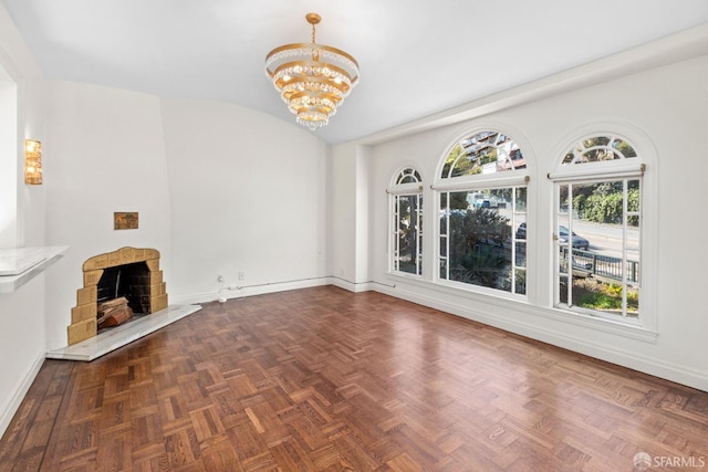 unfurnished living room with baseboards, an inviting chandelier, a fireplace with raised hearth, and vaulted ceiling