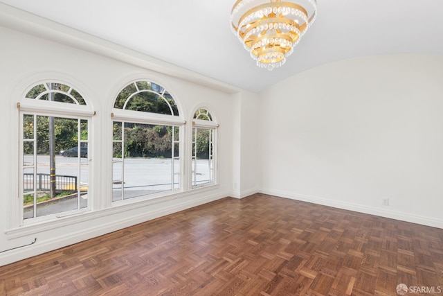 spare room with vaulted ceiling, baseboards, and a chandelier