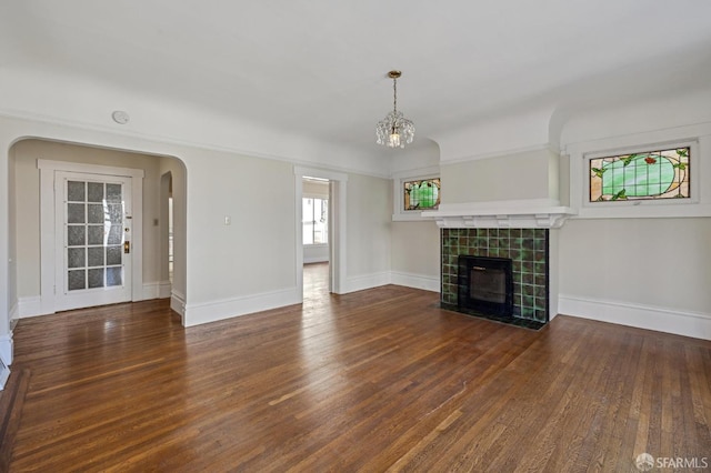 unfurnished living room with dark wood-type flooring and a tile fireplace