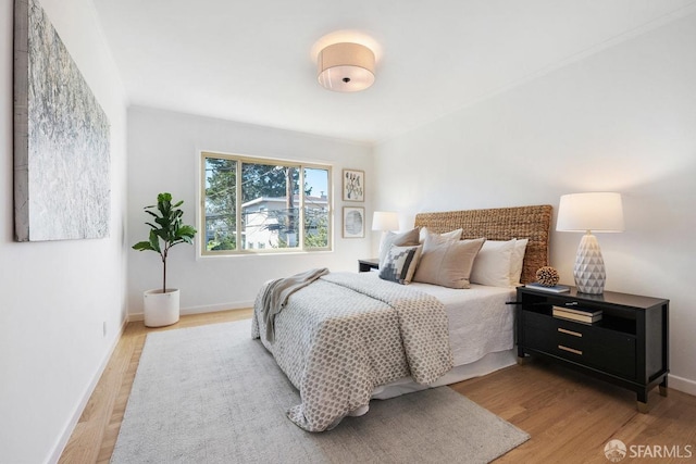 bedroom with wood finished floors and baseboards