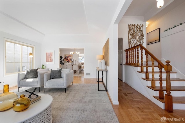 living area featuring a notable chandelier, visible vents, stairs, and baseboards