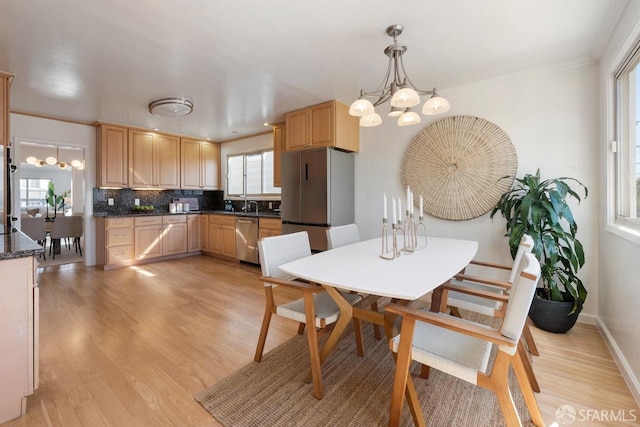 kitchen with tasteful backsplash, dark countertops, appliances with stainless steel finishes, and light brown cabinetry