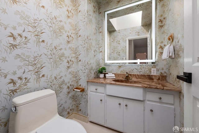 bathroom with toilet and wallpapered walls