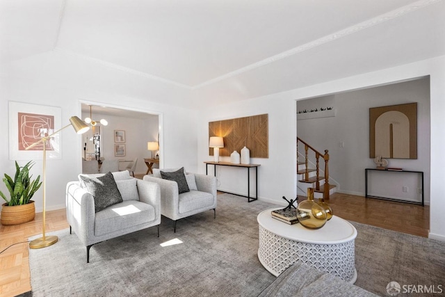 living area featuring baseboards and stairs