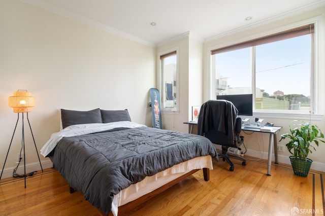 bedroom featuring ornamental molding and light hardwood / wood-style floors