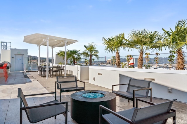 view of patio / terrace with a fire pit and a pergola