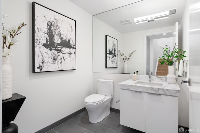 bathroom featuring tile patterned floors, baseboards, toilet, and vanity