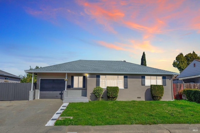 ranch-style home with stucco siding, a lawn, an attached garage, fence, and driveway