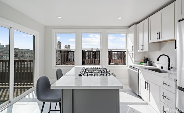 kitchen featuring light stone countertops, sink, stainless steel appliances, and plenty of natural light