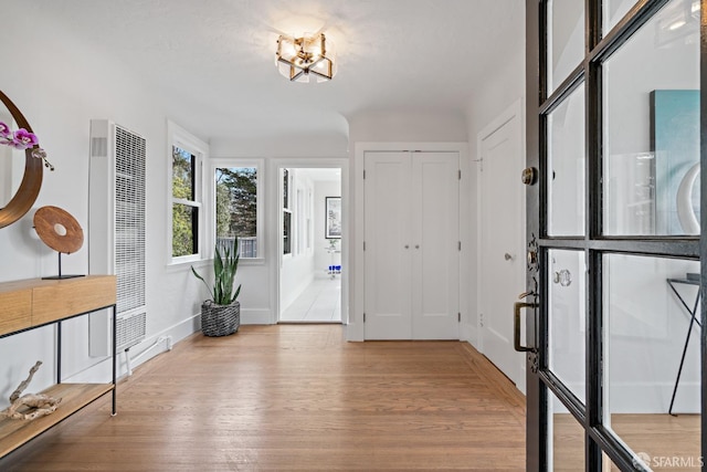 entrance foyer featuring a notable chandelier and light hardwood / wood-style flooring