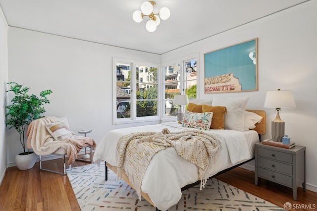 bedroom with an inviting chandelier and wood-type flooring